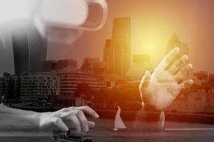 businessman wearing virtual reality goggles in modern office with Smartphone using with VR headset with London city exposure photo