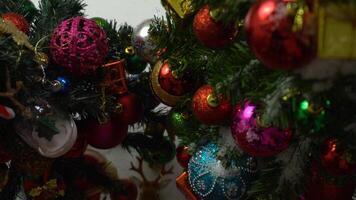 concepto de temporada de saludo ajuste manual de adornos en un árbol de navidad con luz decorativa foto