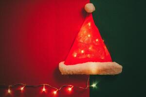 Greeting Season concept.Santa Claus hat with christmas light on red and green background photo