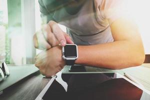 Website designer working with smart watch and digital tablet and digital design diagram on wooden desk as concept photo