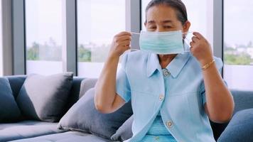 Senior woman wearing protective face masks during quarantine at home. video