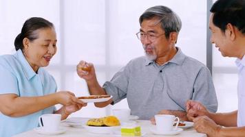 groupe d'amis seniors appréciant de manger sur une table à manger