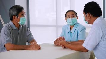 grupo de amigos mayores que usan máscaras protectoras mientras hablan juntos en casa. video