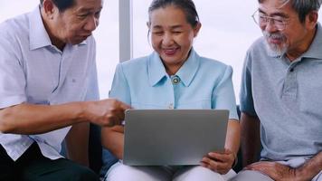 gruppe älterer freunde, die zusammen einen laptop in einem altersheim verwenden. video