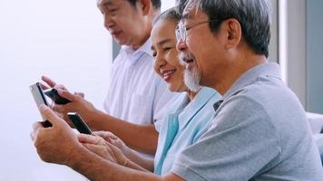 Group of senior friends using smart phone in a retirement home. video