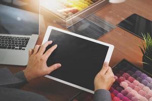 Interior designer hand chosing carpet sample with blank new modern computer laptop and pro digital tablet with material board and digital design diagram layer on wooden desk as concept photo