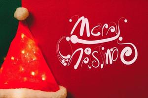 Greeting Season concept.Santa Claus hat with christmas light on red and green background photo