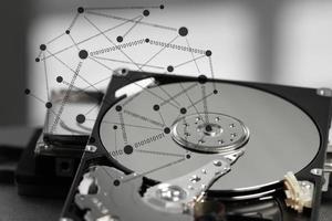 Close up of open computer hard disk drive on desk and notebook photo