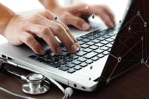 Doctor working with laptop computer in medical workspace office and medical network media diagram as concept photo