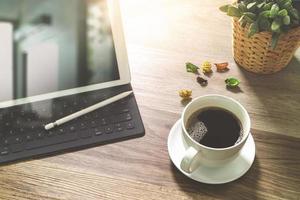 taza de café y teclado inteligente de base de mesa digital, jarrón de hierbas de flores, lápiz óptico sobre mesa de madera, efecto de filtro