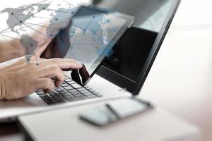 businessman hand  working with tablet and laptop on wooden desk in office photo