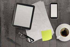 3d empty tablet and a cup of coffee with note pad on the grunge wooden desk photo