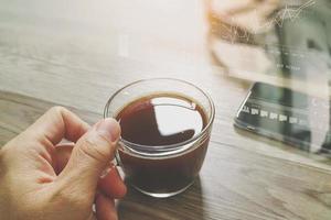 Hand holding Coffee cup or tea and voip headset,smart phone on wooden table,filter effect photo