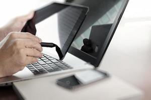 businessman hand  working with tablet and laptop on wooden desk in office photo