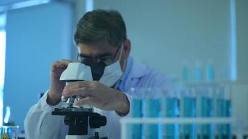 cientista usando microscópio durante experimento no conceito de saúde de laboratório, ciência e tecnologia video