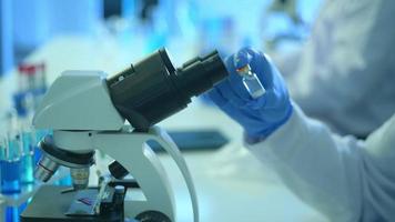 Scientist using microscope during experiment in laboratory, Science and technology healthcare concept video
