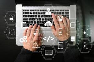 top view of businessman typing keyboard with laptop computer on wooden desk in modern office photo