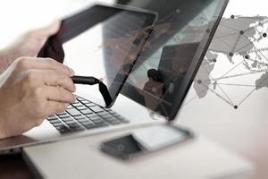 businessman hand  working with tablet and laptop on wooden desk in office photo