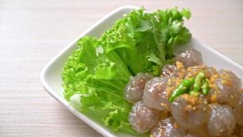 le palline trasparenti sono chiamate saku sai moo o polpette di tapioca al vapore con ripieno di maiale video