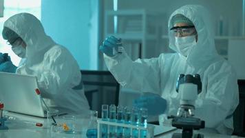 cientista segurando tubo químico líquido no conceito de saúde de laboratório, ciência e tecnologia video