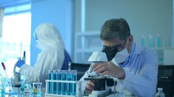 cientista usando microscópio durante experimento no conceito de saúde de laboratório, ciência e tecnologia video