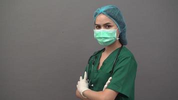 famele doctor wearing protective mask over gray background video