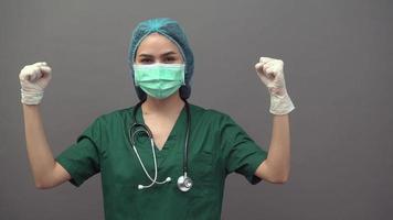 médico famele usando máscara protetora sobre fundo cinza video