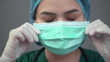 Famele Doctor mit Schutzmaske auf grauem Hintergrund video