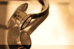 Studio macro of a stethoscope and digital tablet with shallow DOF evenly matched abstract on wood table background copy space photo