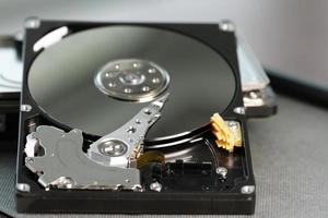 Close up of open computer hard disk drive on desk and notebook