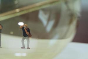 concepto de idea creativa: fotógrafo en miniatura con bombilla vintage en un cuaderno de papel abierto foto