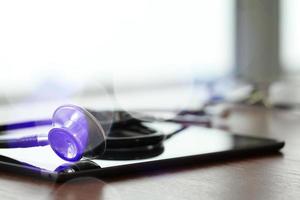 Studio macro of a stethoscope and digital tablet with shallow DOF evenly matched abstract on wood table background copy space photo