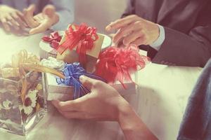 Gift giving Creative Hand and co worker choosing gift. Gift delivery,office party,on marble meeting table,filter film effect photo