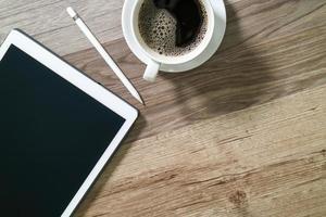 Coffee cup and Digital table dock smart keyboard,eyeglasses,stylus pen on wooden table,filter effect photo