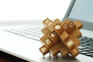 wooden cubes with technology icons on computer as cloud network concept photo