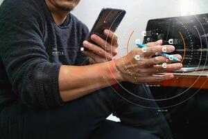 Designer hand using mobile payments online shopping,omni channel,laptop computer on wooden desk in modern office photo