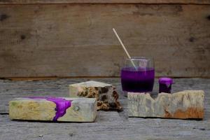 Timber burl woodchips color bottle and resin epoxy for casting wood on old wooden table background photo