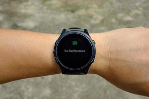 No notification status on modern round-faced GPS multisport digital smartwatch on left hand wrist, selective focus photo