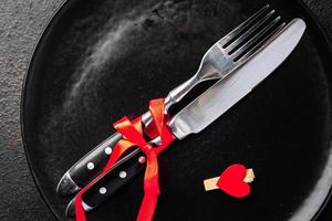 ajuste de la mesa día de san valentín cubiertos tenedor, cuchillo, plato fondo de comida de vacaciones de san valentín foto