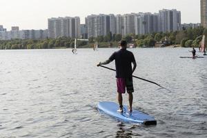 Standup paddleboarding are on the river Moscow, Strogino. photo