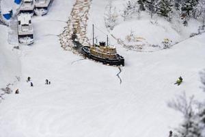 Miniature icebreaker on the river with fishermen. photo