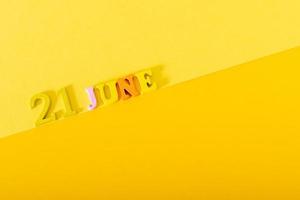 June 21, wooden letters and numbers on a yellow background. photo