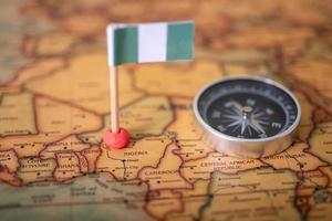 Flag of Nigeria and compass on the world map. photo