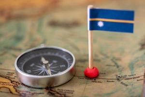 Nauru flag and compass on the world map. photo