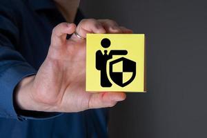 A businessman with a protective gesture and badges of human life insurance. photo