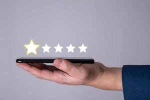 The man uses a mobile phone, and puts 5 stars in the application rating. photo