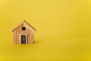A small toy house on a yellow background. photo