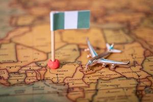 la bandera de nigeria y el avión en el mapa mundial. foto