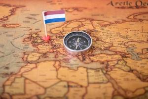 Flag of the Netherlands and compass on the world map. photo