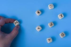 Concept of 5G with icons on wooden cubes. Blue background. photo